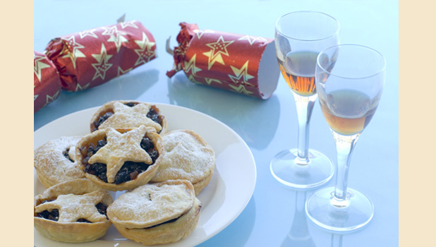 a plate of christmas mincemeat pies and glasses of sherry